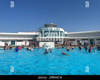 Ein allgemeiner Blick auf die Menschen, die das Hundeschwimmen im Saltdean Lido in Brighton genießen. Bilddatum: Samstag, 9. September 2023. Stockfoto