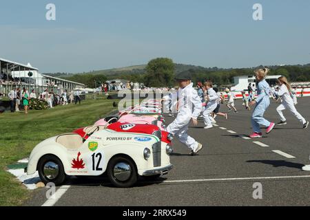 Goodwood, West Sussex, Großbritannien. September 2023. Mädchen und Jungen laufen zu ihren Autos zu Beginn des Settrington Cup Austin J40 Pedalkartenrennen beim Goodwood Revival in Goodwood, West Sussex, UK. © Malcolm Greig/Alamy Live News Stockfoto