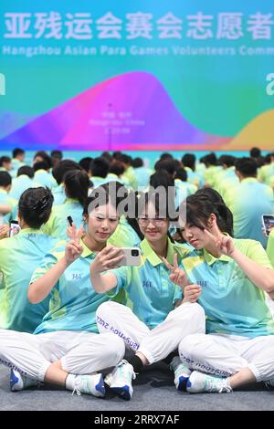 230824 -- HANGZHOU, 24. August 2023 -- Freiwillige nehmen Selfies vor den Hangzhou Asian Games und Hangzhou Asian Para Games ab Freiwillige beginnen die Zeremonie in Hangzhou, der Hauptstadt der ostchinesischen Provinz Zhejiang, 24. August 2023. SPCHINA-HANGZHOU-ASIAN GAMES-VOLUNTEERS-BEGINNZEREMONIE CN HUANGXZONGZHI PUBLICATIONXNOTXINXCHN Stockfoto