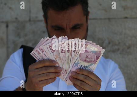 230824 -- ANKARA, 24. Aug. 2023 -- Ein Mann zählt türkische Lira in einer Wechselstube in Ankara, T¹rkiye, am 24. Aug. 2023. Die Zentralbank von T¹rkiye hat am Donnerstag ihren Referenzzinssatz um 750 Basispunkte auf 25 Prozent angehoben, und zwar von 17,5 Prozent, als Gegengewicht zu hoher Inflation und Wechselkursschwankungen. /Handout über Xinhua TRKIYE-ANKARA-BENCHMARK-ZINSANHEBUNG MustafaxKaya PUBLICATIONxNOTxINxCHN Stockfoto