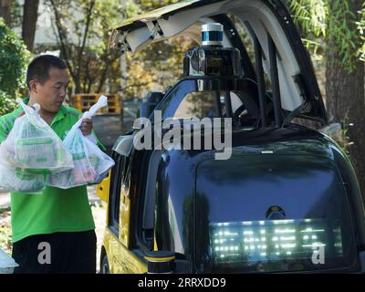 230904 -- PEKING, 4. September 2023 -- Ein Mitarbeiter einer Einzelhandelsplattform stellt von Kunden bestellte Waren in ein unbemanntes Lieferfahrzeug im Bezirk Shunyi in Peking, Hauptstadt von China, am 22. August 2023. Auf der diesjährigen China International Fair for Trade in Services CIFTIS, die vom 2. Bis 6. September in Peking stattfindet, werden unbemannte Lieferfahrzeuge und Drohnen ausgestellt und erhalten viel Aufmerksamkeit. Da Chinas Liefermarkt in den letzten Jahren schnell expandiert, neigen immer mehr Verbraucher dazu, Lebensmittel, Kleidung und andere Artikel online zu bestellen, um Zeit zu sparen. Diese High-Tech-Bereitstellung Stockfoto