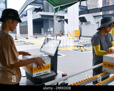 230904 -- PEKING, 4. Sept. 2023 -- Mitarbeiter scannen Kisten mit Lebensmitteln an einem Startplatz der unbemannten Drohne für die Lebensmittellieferung in Shenzhen, Provinz Guangdong in Südchina, 15. August 2023. Auf der diesjährigen China International Fair for Trade in Services CIFTIS, die vom 2. Bis 6. September in Peking stattfindet, werden unbemannte Lieferfahrzeuge und Drohnen ausgestellt und erhalten viel Aufmerksamkeit. Da Chinas Liefermarkt in den letzten Jahren schnell expandiert, neigen immer mehr Verbraucher dazu, Lebensmittel, Kleidung und andere Artikel online zu bestellen, um Zeit zu sparen. Diese High-Tech-Bereitstellungstechnologien haben sich bewährt Stockfoto