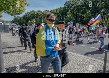 Berlin, Deutschland. September 2023. Ein Mann, stolz in eine ukrainische Flagge gehüllt, wird gewaltsam von Berliner Polizeibeamten weggeführt. (Foto: Michael Kuenne/PRESSCOV/SIPA USA) Credit: SIPA USA/Alamy Live News Stockfoto