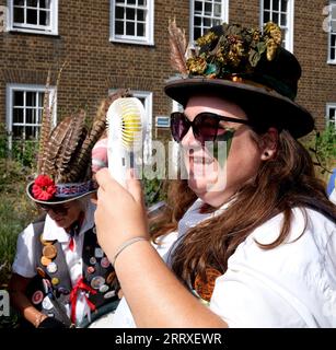 Canterbury, Kent, Großbritannien. September 2023. East Kent Morris Tänzerinnen. Nach dem jährlichen Hop Hoodening Service in Canterbury Cathedral treten Morris-Tänzer ihre traditionellen Tänze in strahlender Hitze mit Hilfe eines Elektroventilators auf, um cool zu bleiben Stockfoto