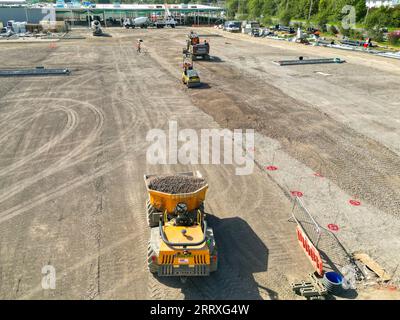 Pontyclun, Wales - 7. September 2023: Drohnen-Ansicht von Maschinen, die zur Vorbereitung des Parkplatzes für eine neue Supermarktentwicklung in Südwales verwendet werden. Stockfoto