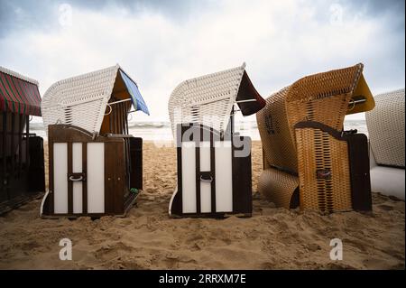 Überdachte Rattan-Liegestühle am ostseestrand, Küste auf der Insel Usedom in Deutschland, Sturm und Regen über dem Brackwasser, hohe Wellen, Stor Stockfoto