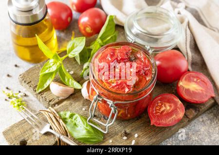 Sonnengetrocknete Tomaten im Glas mit Gewürzen und Kräutern. Gesundes, hausgemachtes fermentiertes Essen. Hauswirtschaft, Herbsternteerhaltung. Stockfoto