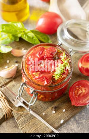 Gesundes, hausgemachtes fermentiertes Essen. Sonnengetrocknete Tomaten im Glas mit Gewürzen und Kräutern. Hauswirtschaft, Herbsternteerhaltung. Stockfoto