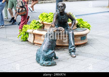 BUDAPEST, UNGARN - 7. JULI 2023: Mädchen spielt mit Hundestatue in Budapest, Ungarn am 7. Juli 2023 Stockfoto
