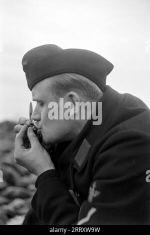 Der Fotograf Erich Andres in der Uniform der Kriegsmarine isst Muscheln am Strand von Le Havre, 1940. Der Fotograf Erich Andres in seiner Kriegsmarine-Uniform, die Muscheln am Strand von Le Havre, 1940, isst. Stockfoto