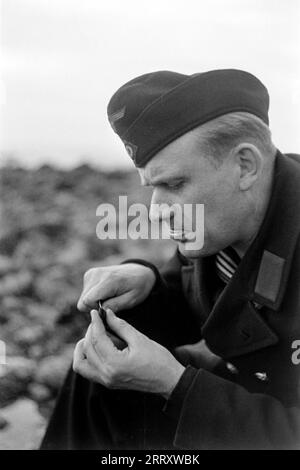 Der Fotograf Erich Andres in der Uniform der Kriegsmarine öffnet Muscheln am Strand von Le Havre um sie zu verzehren, 1940. Der Fotograf Erich Andres öffnet in seiner Kriegsmarine-Uniform Muscheln am Strand von Le Havre, um sie zu essen, 1940. Stockfoto