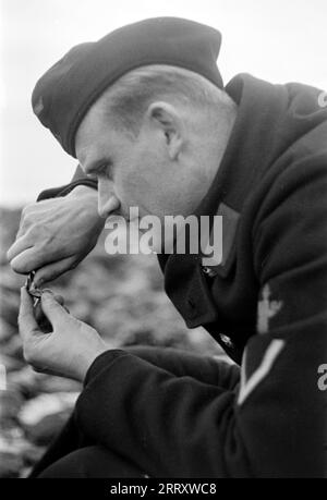 Der Fotograf Erich Andres in der Uniform der Kriegsmarine öffnet Muscheln am Strand von Le Havre um sie zu verzehren, 1940. Der Fotograf Erich Andres öffnet in seiner Kriegsmarine-Uniform Muscheln am Strand von Le Havre, um sie zu essen, 1940. Stockfoto