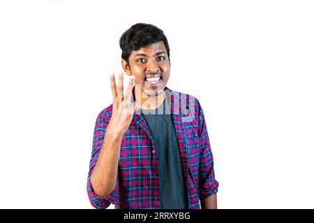 Ein Mann hebt seine Hand mit drei ausgestreckten Fingern. Der Hintergrund ist klar. Stockfoto