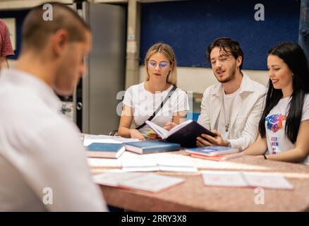 Die Studenten versammelten sich am Tisch und lernten zusammen, um die Prüfung vorzubereiten Stockfoto