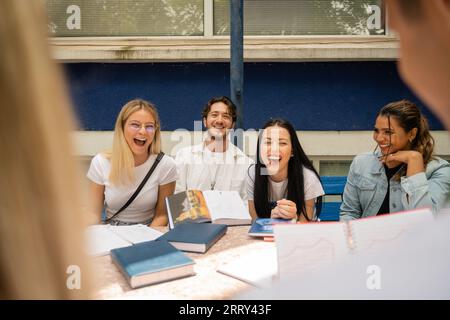 Multikulturelle Studenten, die sich an einer gemeinsamen Diskussion auf dem Campus Yard beteiligen Stockfoto