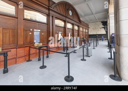 Bahnreisende stehen Schlange, um Bahntickets am Kartenbüro des Bahnhofs Manchester Victoria zu kaufen Stockfoto