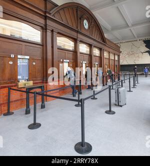 Bahnreisende stehen Schlange, um Bahntickets am Kartenbüro des Bahnhofs Manchester Victoria zu kaufen Stockfoto