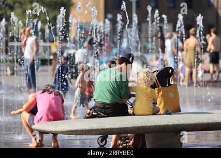 Familien, die die kühlenden Springbrunnen am Granary Square am Kings Cross in der Hitzewelle im September 2023 im Norden Londons, Großbritannien, genießen Stockfoto