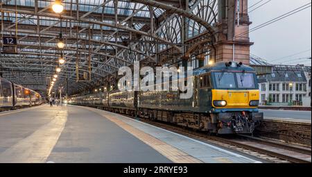 Baureihe 92 Elektrolokomotiv92014 am Bahnhof Glasgow Central mit Kaledonischer Tieflandschlupfbahn, die in der Abenddämmerung auf die Abfahrt wartet Stockfoto