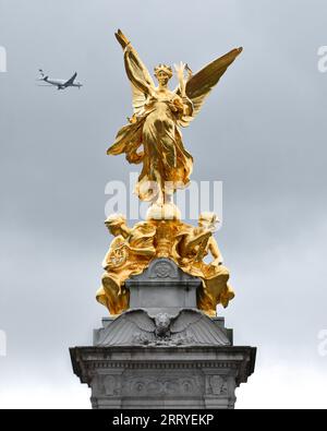 Goldene Statue auf dem Victoria Memorial, die einen Gilded Winged Victory zeigt, der auf einem Globus steht und eine siegerpalme trägt. Die Mall, London Stockfoto