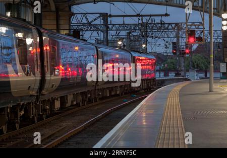 Der Tiefland-Kaledonien-Schlafzug wartet auf die Abfahrt vom Glasgow Central Station mit einem roten Signal, das an der Seite des Zuges glitzert Stockfoto