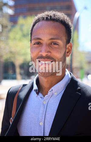 Vertikales Porträt eines jungen erwachsenen Latino-Geschäftsmannes mit glücklichem Ausdruck. Kommerziell männlich formell. Stockfoto