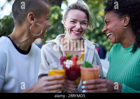 Drei fröhliche, reife, multiethnische Frauen, die im Freien feiern. Gruppe glückliche Erwachsene Frau. Stockfoto