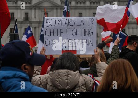 Santiago, Chile. September 2023. Eine Frau mit einem Schild feiert 50 Jahre Militärputsch. Chilenische Patrioten versammeln sich vor dem Palacio de la Moneda, um den 50. Jahrestag des Staatsstreichs zu feiern, den der Diktator Augusto Pinochet am 11. September 1973 gegen Präsident Salvador Allende verübt hat. Immer geschützt durch die chilenische Polizei, die sich über das Geschehene lustig macht. Quelle: SOPA Images Limited/Alamy Live News Stockfoto