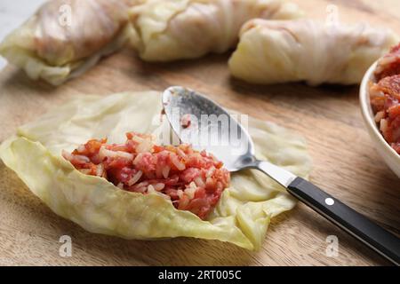 Ich bereite gefüllte Kohlrollen auf Holzbrettern vor, Nahaufnahme Stockfoto