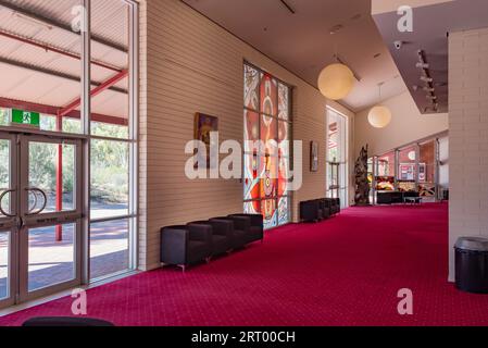 Durchscheinende einheimische Kunst färbt die Frontfenster des Araluen Arts Centre in der Nähe von Alice Springs (Mparntwe) im Northern Territory, Australien Stockfoto