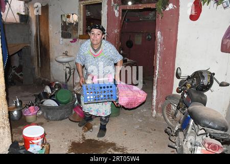 (230910) -- MARRAKESCH, 10. September 2023 (Xinhua) -- Eine Frau reinigt ihr beschädigtes Haus nach einem Erdbeben der Stärke 6,8 in Tahannaout, Marokko, 9. September 2023. Ein Erdbeben der Stärke 6,8 traf Marokko am Freitag um 23:11 Uhr Ortszeit (2211 GMT) in einer Tiefe von 18,5 km, so der United States Geological Survey. Das Epizentrum des Erdbebens lag in der Nähe der Stadt Ighil in der Provinz Al Haouz, etwa 70 km südwestlich von Marrakesch.das Beben hat 2.012 Menschen das Leben gekostet und 2.059 verletzt, wobei 1.404 von ihnen in ernstem Zustand waren. nach dem neuesten Stand des Innenministeriums des Landes auf Satu Stockfoto