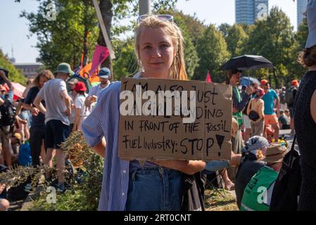 Den Haag, Niederlande. September 2023. Eine Demonstrantin hält ihr Plakat, um ihre Meinung während der Demonstration zu äußern. Tausende von Klimaaktivisten der Extinction Rebellion blockierten die Autobahn A12 in den Haag, Niederlande. Sie versuchen, die Regierung unter Druck zu setzen, aufgrund des Klimawandels sofort keine Investitionen in fossile Brennstoffe mehr zu tätigen. Quelle: SOPA Images Limited/Alamy Live News Stockfoto