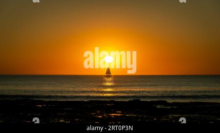 Silhouette eines Segelbootes, ausgerichtet auf die Sonne bei Sonnenuntergang Stockfoto