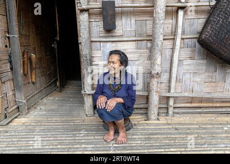 Eine ältere Frau des Apatani-Stammes mit traditionellen schwarzen Nasensteckern und Gesichtstattoos, die in einem ländlichen Dorf im Ziro-Tal in Indien lächelt. Stockfoto