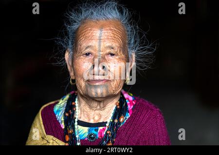Porträt einer älteren indianischen Apatani-Stammesfrau mit schwarzen hölzernen Nasenstopfen und traditionellen Gesichtstattoos, Arunachal Pradesh, Indien Stockfoto