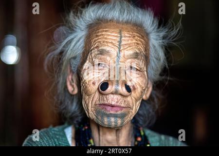 Porträt einer älteren indianischen Apatani-Stammesfrau mit schwarzen hölzernen Nasenstopfen und traditionellen Gesichtstattoos, Arunachal Pradesh, Indien Stockfoto