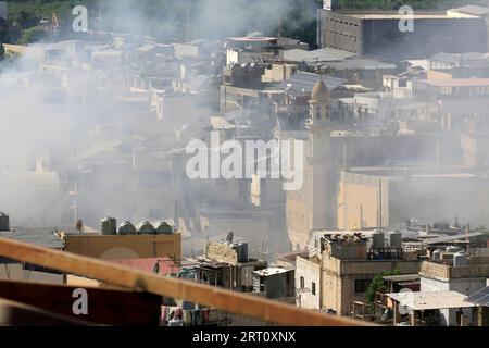 Beirut, Libanon. September 2023. Rauch steigt aus Häusern im palästinensischen Flüchtlingslager Ain Al-Helweh in der Nähe von Sidon, Südlibanon, 9. September 2023. Bewaffnete Auseinandersetzungen zwischen Mitgliedern der Fatah-Bewegung und islamischen Militanten im palästinensischen Flüchtlingslager Ain Al-Helweh im Südlibanon intensivierten sich am Samstag, wobei zwei Menschen getötet und elf weitere verletzt wurden, berichtete die nationale Nachrichtenagentur. Die Zusammenstöße führten zu einer neuen Welle der Vertreibung aus dem Lager, als Hunderte von Familien in der Halle der Mosuli-Moschee in der Stadt Sidon Zuflucht suchten. Kredit: Ali Hashisho/Xinhua/Alamy Live News Stockfoto