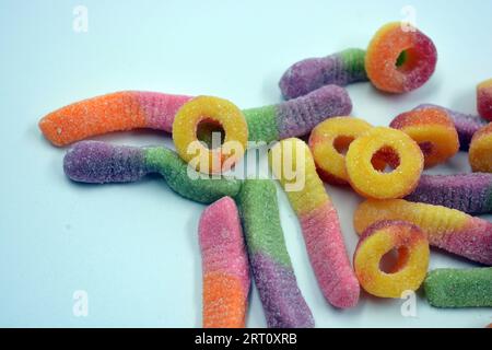 Schöne und leuchtend farbige Süßigkeiten von Kinderbonbons in Form von süßen Regenwürmern in verschiedenen Farben, amerikanischen Donuts, Lutscher. Stockfoto