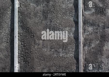 Alter schwarzer Dachfilz oder Bitumen an einer Wand. Hintergrundstruktur Stockfoto