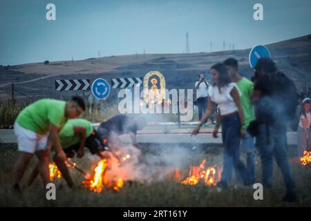 Guadalajara, Spanien. September 2023. Die Devotees zünden ein Lagerfeuer an, während die Jungfrau von Peñahora vorbeizieht. Die Gläubigen der Jungfrau von Peñahora in der Stadt Humanes, Guadalajara, feiern die Feuerprozession, die fast zwei Kilometer von einer Eremitage in Richtung Stadt führt, während auf dem Weg Lagerfeuer aus Stroh und Brennholz verbrannt werden, um die Feierlichkeiten zu ihren Ehren zu feiern. Quelle: SOPA Images Limited/Alamy Live News Stockfoto