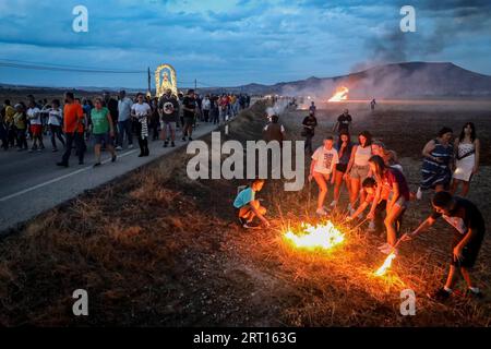 Guadalajara, Spanien. September 2023. Die Devotees zünden ein Lagerfeuer an, während die Jungfrau von Peñahora vorbeizieht. Die Gläubigen der Jungfrau von Peñahora in der Stadt Humanes, Guadalajara, feiern die Feuerprozession, die fast zwei Kilometer von einer Eremitage in Richtung Stadt führt, während auf dem Weg Lagerfeuer aus Stroh und Brennholz verbrannt werden, um die Feierlichkeiten zu ihren Ehren zu feiern. Quelle: SOPA Images Limited/Alamy Live News Stockfoto