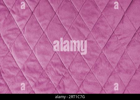 Hintergrund aus gestepptem Velours. Pinke Textur Decke oder Pufferjacke, mit Rautenmuster, weiche, zerknitterte Oberfläche, gekräuseltes Textil Stockfoto