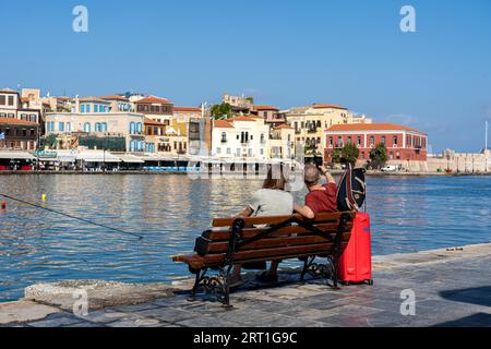 Chania, Griechenland, 22. September 2021: Ein junges Paar, das ein Selfie auf einer Bank am alten venezianischen Hafen macht Stockfoto