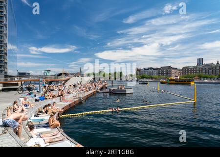 Kopenhagen, Dänemark, 30. Juni 2022: Die Menschen genießen die Sonne an der Kalvebod-Welle, einer hölzernen Promenade am Hafenufer Stockfoto