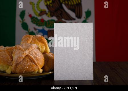 Totes Brot und leere Karte mit mexikanischer Flagge im Hintergrund. Tag des toten Mockups. Stockfoto