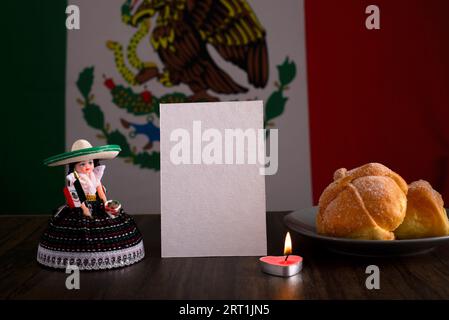 Totes Brot, mexikanisches Kunsthandwerk und leere Karte mit mexikanischer Flagge im Hintergrund. Tag des toten Mockups. Stockfoto