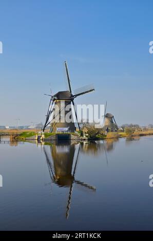 Die Mühlen Kinderdijk spiegelten sich an einem klaren, sonnigen Frühlingstag in fast gerilltem Wasser wider Stockfoto