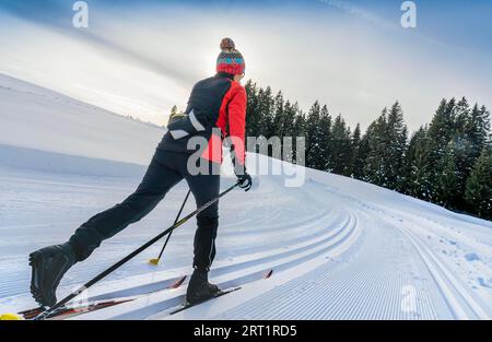 Hübsche aktive Seniorenläuferin im frisch gefallenen Pulverschnee in den Allgäuer Alpen bei Immenstadt, Bayern Stockfoto