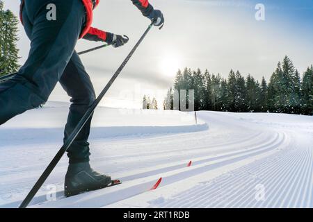 Hübsche aktive Seniorenläuferin im frisch gefallenen Pulverschnee in den Allgäuer Alpen bei Immenstadt, Bayern Stockfoto