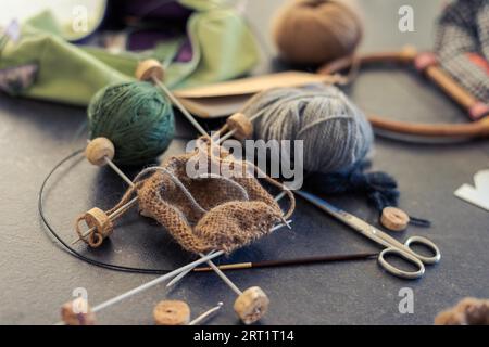 Chaotisch kreatives Chaos auf dem Tisch beim Stricken von Socken Stockfoto